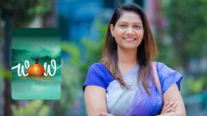 "A smiling Indian woman, wearing a blue and silver saree, poses outdoors with her arms crossed. To her left is a promotional graphic for the IDFC FIRST WOW credit card.