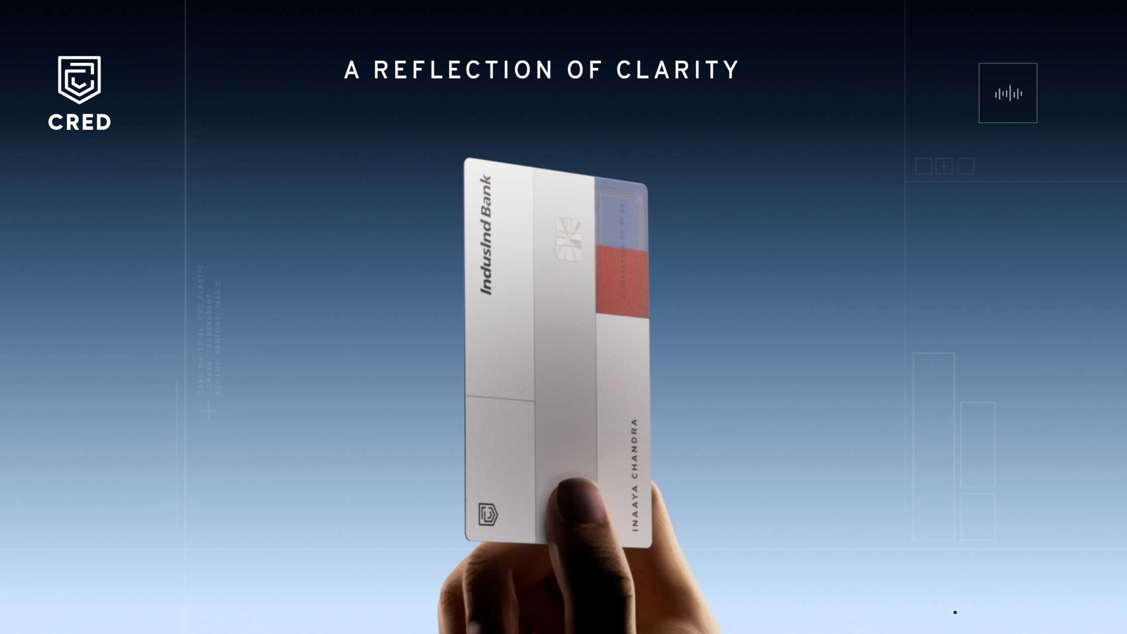 A hand holding the minimalist white CRED IndusInd Bank RuPay Credit Card against a blue background, with the text 'A REFLECTION OF CLARITY'.