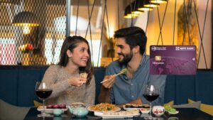 A young couple enjoying dinner at a restaurant while using the HDFC Diners Club Privilege Credit Card for dining rewards and lifestyle benefits.