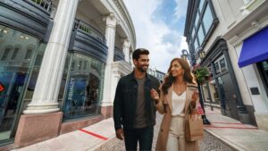 Modern Indian woman shopping on Rodeo Drive in the US using her international credit card, traveling with her partner—showcasing the best international travel credit card in India.